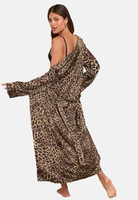 Leopardmönstrad lång cardigan i mjukt tyg, med löst sittande passform, öppning framtill och vida ärmar. Färgpalett som inkluderar beige, brunt och svart.