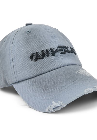Light blue denim baseball cap with a curved brim. Features black embroidered text and distressed accents on the brim and sides.