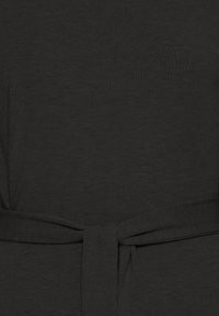 Gros plan sur une ceinture en tissu gris foncé nouée dans un simple nœud autour d'un matériau texturé assorti.