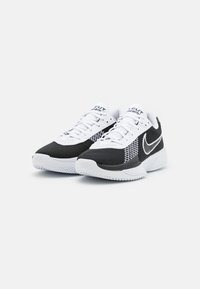 Et par svarte og hvite Nike idrettssko med nettingoverdel, snøring og polstret såle på hvit bakgrunn.