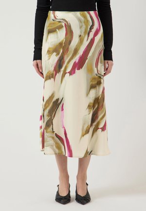 Midi sukňa s abstraktným hnedým, béžovým a ružovým vzorom, nosená s čiernym topom a čiernymi lodičkami so špicatou špičkou.