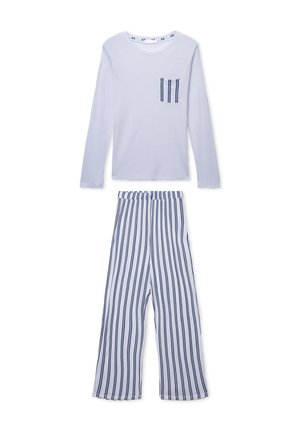 Top bianco a maniche lunghe con tasca a righe abbinato a pantaloni bianchi a gamba larga con strisce verticali blu e nere.