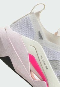 Lekka sneaker z różowo-białą teksturowaną cholewką, akcentami z siateczki oraz charakterystyczną czarno-różową podeszwą z detalem z logo.