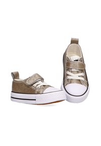 Zapatillas de lona doradas y brillantes con suelas de goma blanca, con cordones y una correa de velcro. Punta redonda, con parte superior texturizada y una franja negra contrastante.