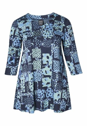 Tunică bleu marin cu decolteu în V, având un amestec de modele deschise de albastru și verde, inclusiv pătrate și stropi, dintr-un material moale.