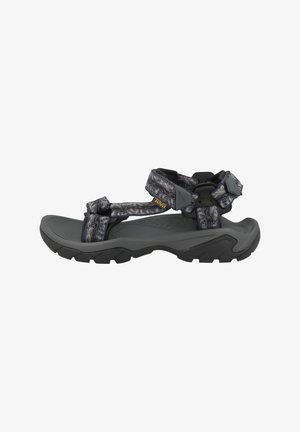 Graue und schwarze Outdoorsandale mit robuster Sohle und verstellbaren, gemusterten Riemen, entwickelt für Komfort und Haltbarkeit.