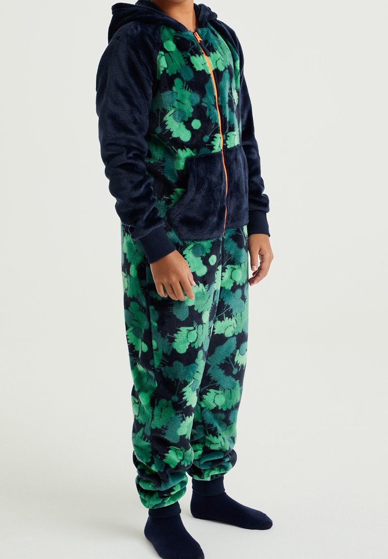 Mono de forro polar en azul marino oscuro con un patrón floral verde, con capucha, bolsillo frontal y puños elásticos en los tobillos.