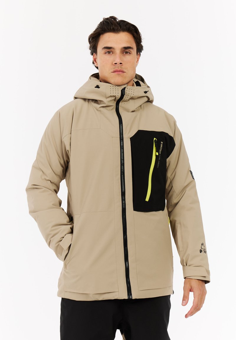 Beige Außenjacke mit Kapuze, ausgestattet mit einer schwarzen Reißverschlusstasche und neon-gelber Reißverschlussdetail. Das Material wirkt glatt mit einem matten Finish.