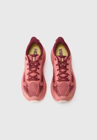 Pink athletic shoes with a breathable mesh upper featuring maroon accents, lace-up front, cushioned sole, and a textured design.