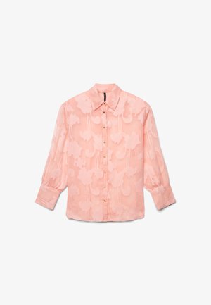 Blouse rose semi-transparente avec motif floral, manches longues bouffantes, devant boutonné et col pointu, posée à plat sur un fond blanc.