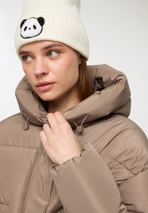 Giacca a vento color taupe con colletto alto, cordini regolabili e una texture morbida. Abbinata a un berretto bianco a coste con un design di panda.