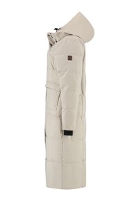 Lange beige gewatteerde winterjas met een vaste capuchon, zijzakken en een logopatch op de bovenarm, zichtbaar vanaf de zijkant.