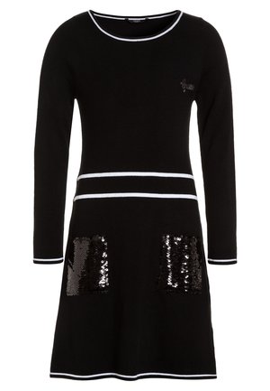 Czarna dzianinowa sukienka z długimi rękawami, białe wykończenie przy dekolcie i na dole, z dwoma cekinowymi kieszeniami. Krój w kształcie litery A i miękka tekstura.