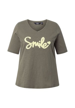 T-shirt à col en V vert olive avec manches courtes, arborant le mot « Smile » en grande écriture cursive couleur crème et un petit détail en forme de cœur.