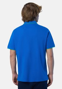 Polo shirt blu royal con maniche corte, accento verde sul colletto e orlo dritto. Realizzato in tessuto morbido e testurizzato.