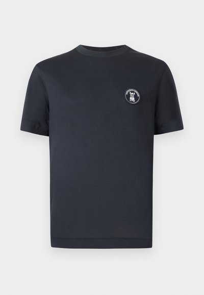 Κοντομάνικη μπλούζα σε ναυτικό μπλε με στρογγυλή λαιμόκοψη και μικρό στρογγυλό ένθετο με σκύλο και το κείμενο «EMPORIO ARMANI» στο αριστερό στήθος.