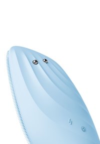 Blå silikon ansiktsrengöringsapparat med ribbad yta, två silverknappar och en texturerad sida med små borst och ikoner.