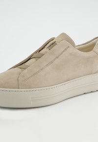 Beiger Wildleder-Sneaker mit elastischen Schnürsenkeln, glatter Textur und dicker weißer Gummisohle. Verfügt über ein minimalistisches Design und Nahtdetails.