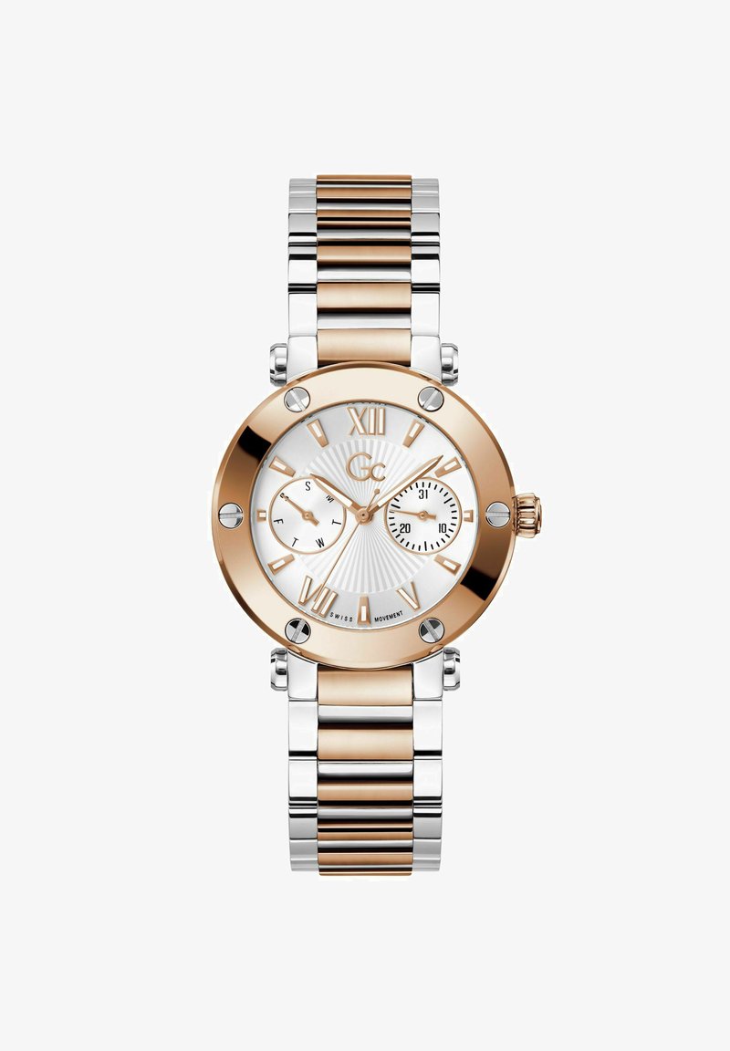 Kuld- ja hõbe metallkell valge numbriga, rooma numbrite markerite ja kahe aladialiga. Omab tekstureeritud tausta ja poleeritud pinda.