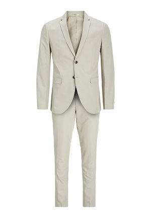 Beige kostym bestående av en figursydd kavaj med två knappar och byxor. Tyget verkar mjukt med en subtil textur och inga synliga mönster.