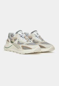 Sneaker caratterizzati da una combinazione di beige chiaro, mesh grigio e materiali in suede, con una suola bianca spessa e una linea di accento verde.