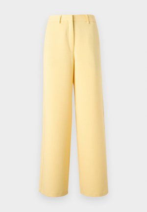 Pantaloni gialli a vita alta, gamba larga, con passanti per cintura, cucitura frontale e chiusura anteriore nascosta su uno sfondo chiaro e uniforme.