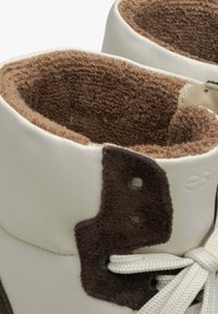 Bílé vysoké tenisky s měkkým hnědým interiérem, suédovými akcenty a bílými tkaničkami; límec je lemovaný texturovanou látkou.