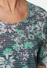 Bloemmotief top met een ronde halslijn, versierd met groene, witte en roze bloemen op een zwart gestreepte achtergrond; textuurstof.
