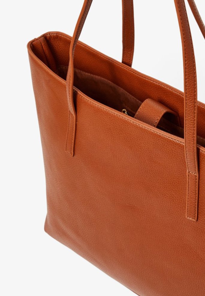 Bolso tote de cuero marrón con dos asas largas, forma rectangular, textura suave y un gran compartimento principal para almacenaje.