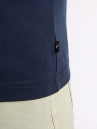 Námořnické modré bavlněné tričko s klasickým střihem, zdobené švy a malou černou etiketou na bočním švu.