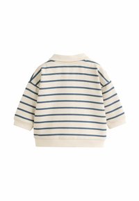 Beige hosszú ujjú felső tengeri kék vízszintes csíkkal. Bordázott nyakkivágással és mandzsettákkal rendelkezik, puha pamut anyagból készült, és laza szabású.