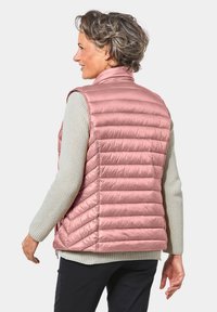 Lichte puffer vest in een zachte rozenkleur met een horizontaal doorgestikt ontwerp. Heeft een hoge kraag, zijritsen en een gladde, glanzende textuur.