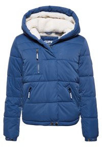 Blauwe gewatteerde jas met een grote capuchon, fleece voering, voorkant met rits en meerdere ritszakken. Heeft een cropped ontwerp en drukknoopsluiting.