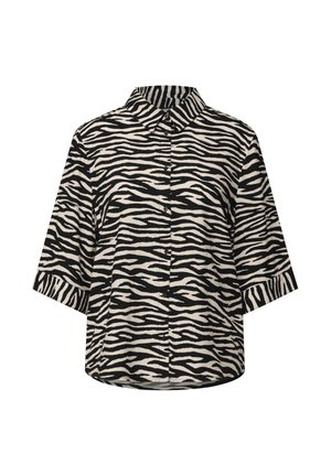 Blouse à manches courtes présentant un motif rayé noir et blanc de zèbre, avec un col et un boutonnage sur le devant, fabriquée en tissu léger.