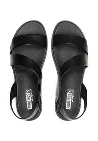 Sandalias de cuero negro con tres correas anchas, plantilla texturizada y correa en el talón. Presenta un sutil detalle de costura elevada a lo largo de la suela.