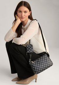 Borsa a tracolla nera con motivo, dotata di una mini pochette rimovibile, caratterizzata da una texture liscia, accessori in argento e tracolla regolabile.