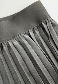 Szara plisowana spódnica z szerokim pasem i delikatnym połyskiem, z pionowymi fałdami tkaniny o różnej fakturze i rozmieszczeniu.