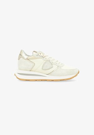 Sneakers in light cream and beige suede, featuring a silver accent on the heel and a textured sole, with a low-profile design.