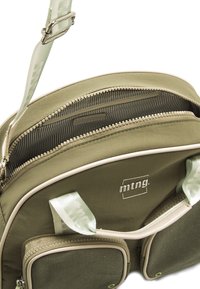 Olivgr�üne Tasche mit einer texturierten Oberfläche, doppelten Reißverschlussfächern und cremefarbenen Akzenten. Verstellbarer Tragegurt mit einem gemusterten Detail.