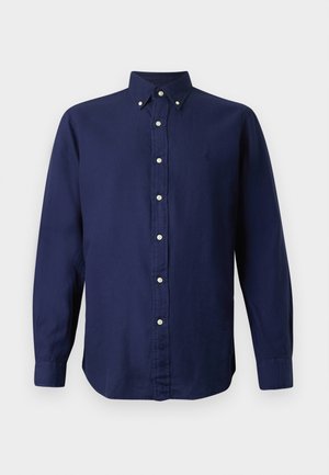 Camicia a maniche lunghe blu navy con colletto a bottoni, bottoni frontali e un piccolo logo ricamato sul lato sinistro del petto. Tessuto con una consistenza liscia.