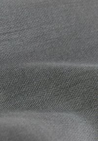 Tissu gris avec un tissage fin et texturé, présentant des variations subtiles de teinte et une surface lisse. Aucun motif ou embellissement visible.