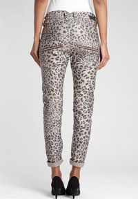 Jean imprimé léopard avec une base grise, doté de revers roulés, de poches arrière et d'accents en matériel noir. Texture lisse.