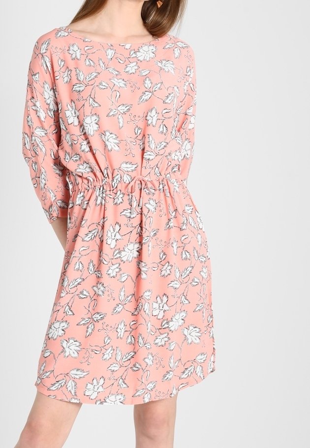 Blommig klänning i korall med vitt och svart blommönster, med lös passform, tre fjärdedelsärmar och elastisk midja.