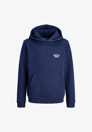 Tumesinine kapuutsiga sviiter, millel on eesmine tasku ja logo, koos helesiniste laia lõikega teksade ja beežide kingadega, seismas neutraalsel taustal.