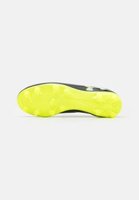 Must must mängujalatsid, millel on tekstuuriga pealisosa, erksate kollaste tallade ja vastupidavate naeltega haardevõimekuse tagamiseks. Nähtav "Under Armour" brändimine.