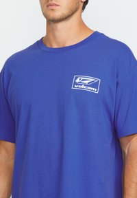 Blauwe katoenen t-shirt met een witte Volcom-logo op de linker borst en een klassiek ronde hals ontwerp. Korte mouwen en een ontspannen pasvorm.