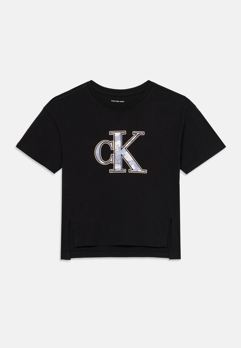 Camiseta corta negra de algodón, con un gran logo "ck" en gris y blanco con acentos metálicos. Mangas cortas, con aberturas laterales.