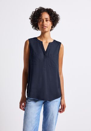 Ärmellose dunkelblaue Bluse mit V-Ausschnitt, zwei Brusttaschen und leicht gerundetem Saum. Weicher Stoff mit glatter Textur.