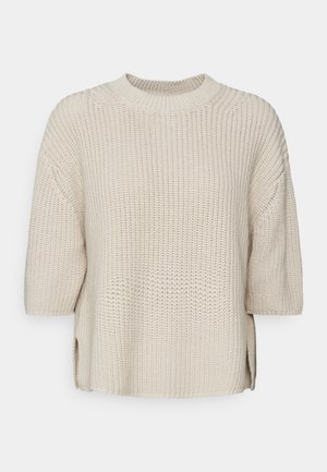Beige knitted sweater with a round neckline, short sleeves, and side slits. Features textured fabric for added dimension.