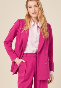 Fuchsia dubbele-breasted blazer met twee voorkzakken, gecombineerd met een gestreept overhemden met knopen. Gladde textuur, getailleerde pasvorm en contrasterende kleuren.